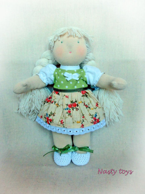 A handmade Waldorf doll called Lelya with long rooted hair and removable clothes.