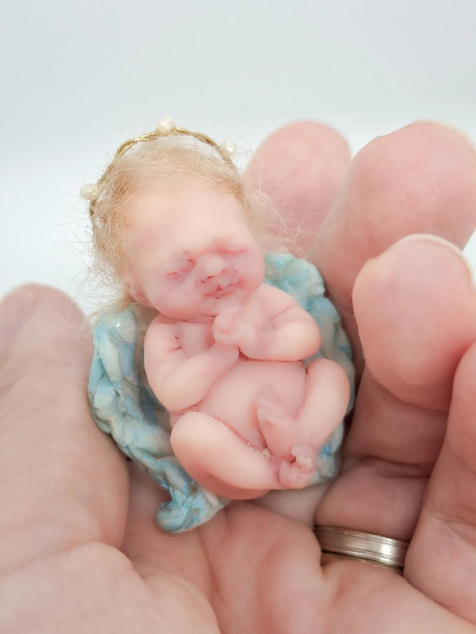 OOAK miniature angel sculpture 'The Keeper' holding a sacred gesture, handcrafted from polymer clay for the Divine Collection.