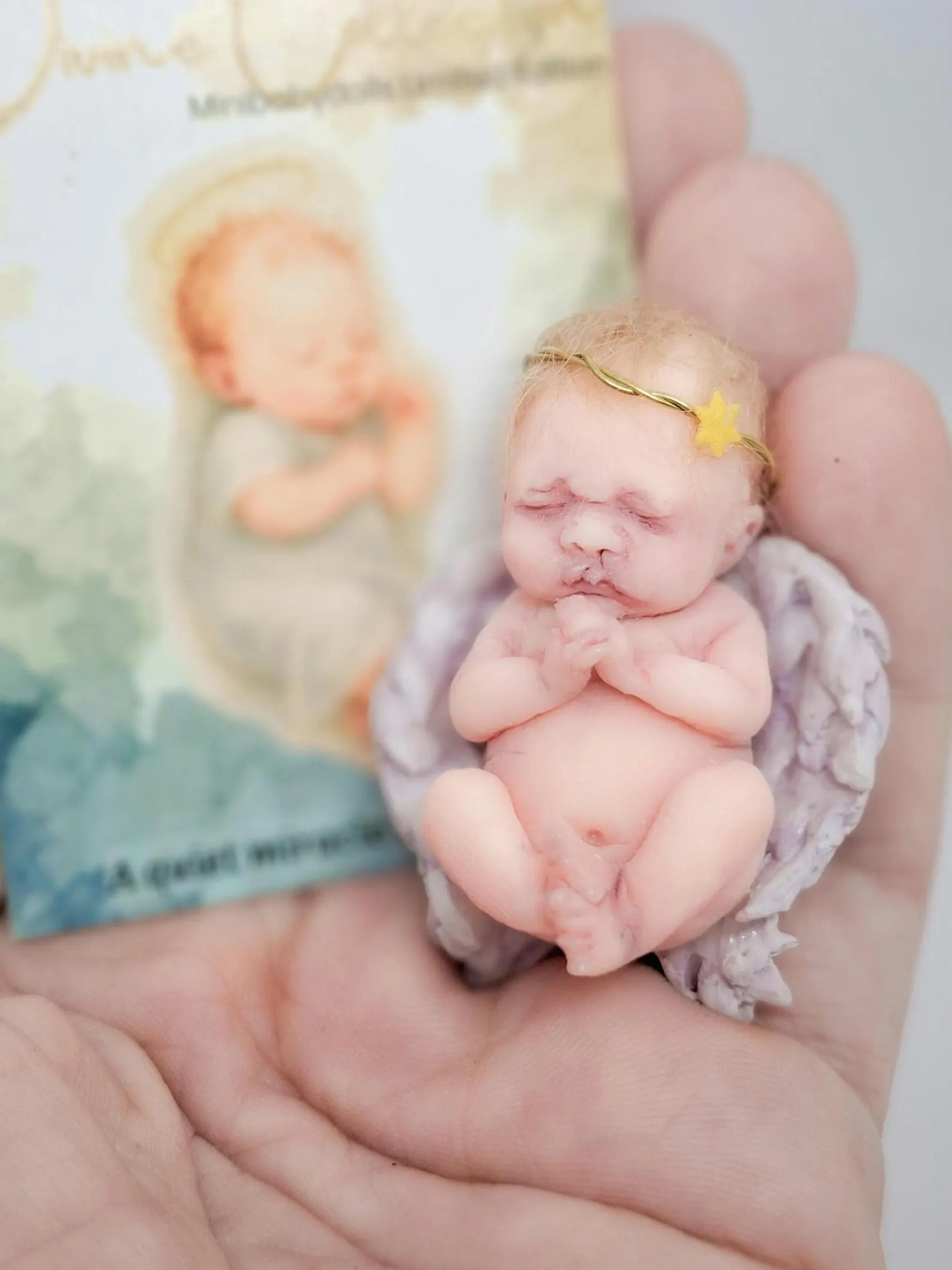 Handmade polymer clay miniature angel doll 'The Witness' in a peaceful pose, part of the Divine Collection by minibabydolls.