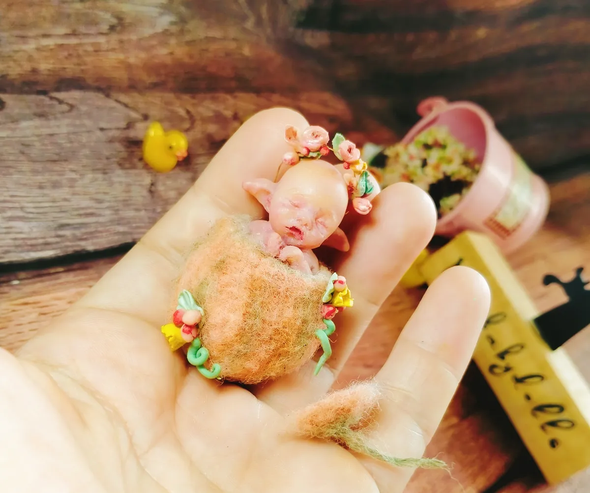 Whimsical OOAK miniature baby doll with orange flower crown, posed in a charming vintage miniature scene with tiny accessories - by Mini Baby Dolls