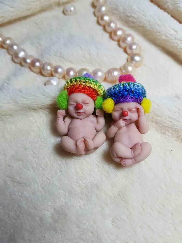 Playful pair of OOAK miniature clown baby dolls with rainbow-colored crocheted hair and red noses, displayed together with pearl beads - by Mini Baby Dolls