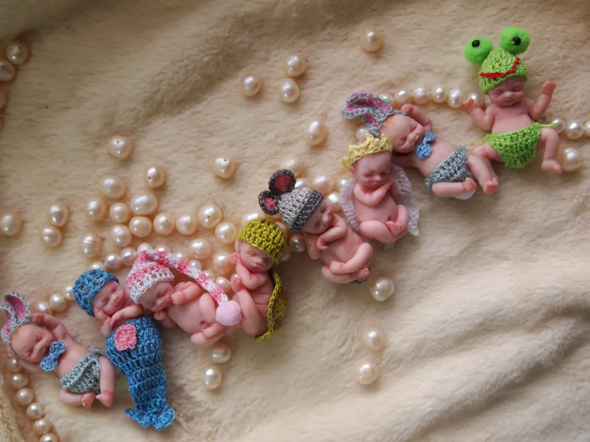 Collection of OOAK miniature dolls and figurines including babies in colorful outfits, tiny frogs, and crocheted accessories - by Mini Baby Dolls