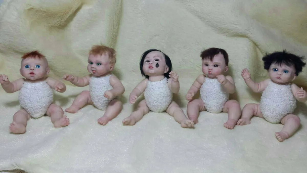 Five detailed OOAK miniature toddler dolls sitting in a row, each wearing different crocheted outfits and hairstyles - by Mini Baby Dolls