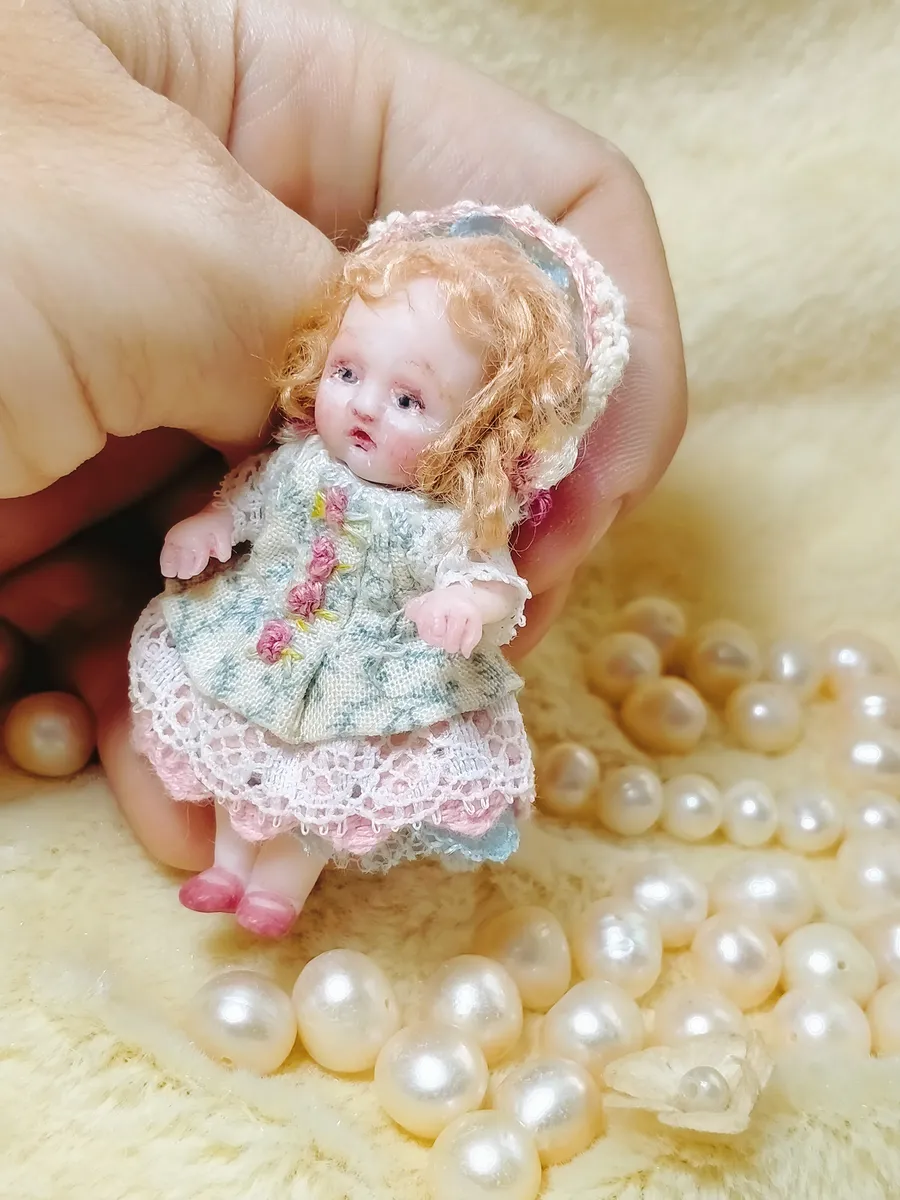 Exquisite OOAK miniature toddler doll with curly blonde hair in vintage floral dress with lace bonnet, surrounded by pearl beads - by Mini Baby Dolls