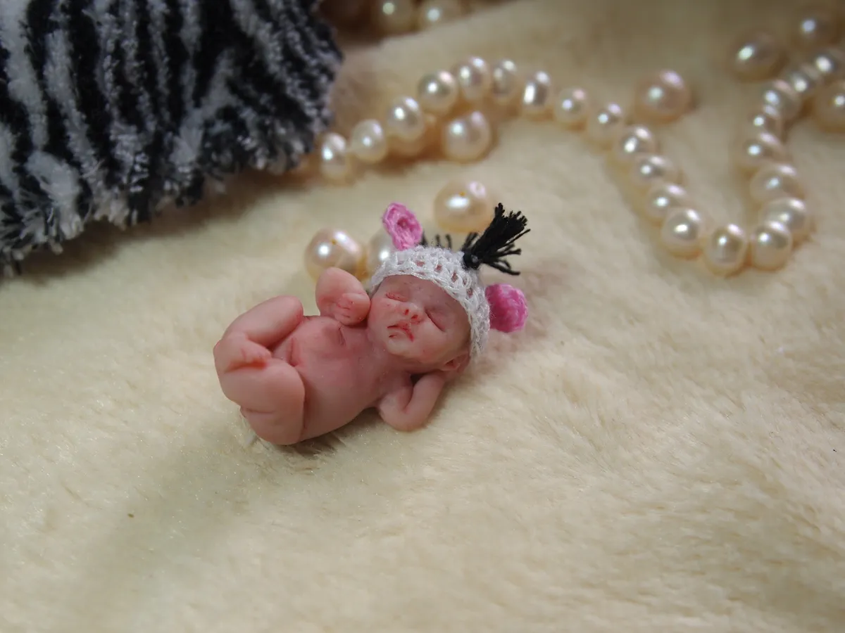 Sleeping OOAK miniature baby doll in delicate white crocheted bonnet with pink heart, on zebra print with pearls - by Mini Baby Dolls